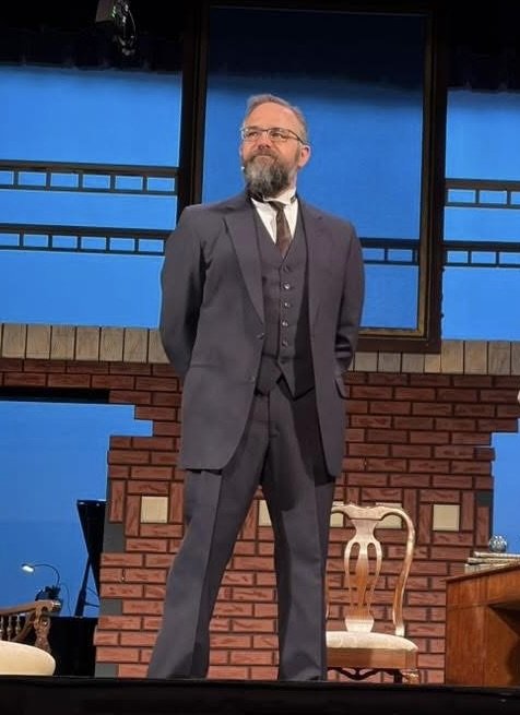 Garrett Michael Brown on stage in a three-piece suit
